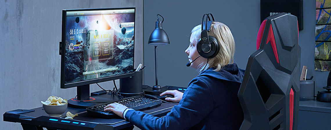 Child at desk in the middle of computer game Child at desk in the middle of computer game