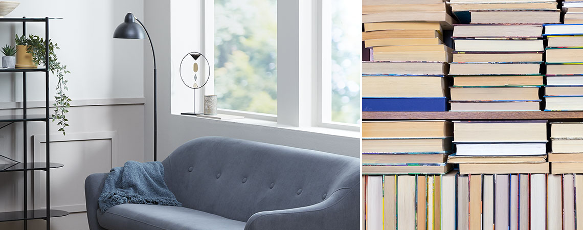 Living room with sofa and reading light and a pile of books
