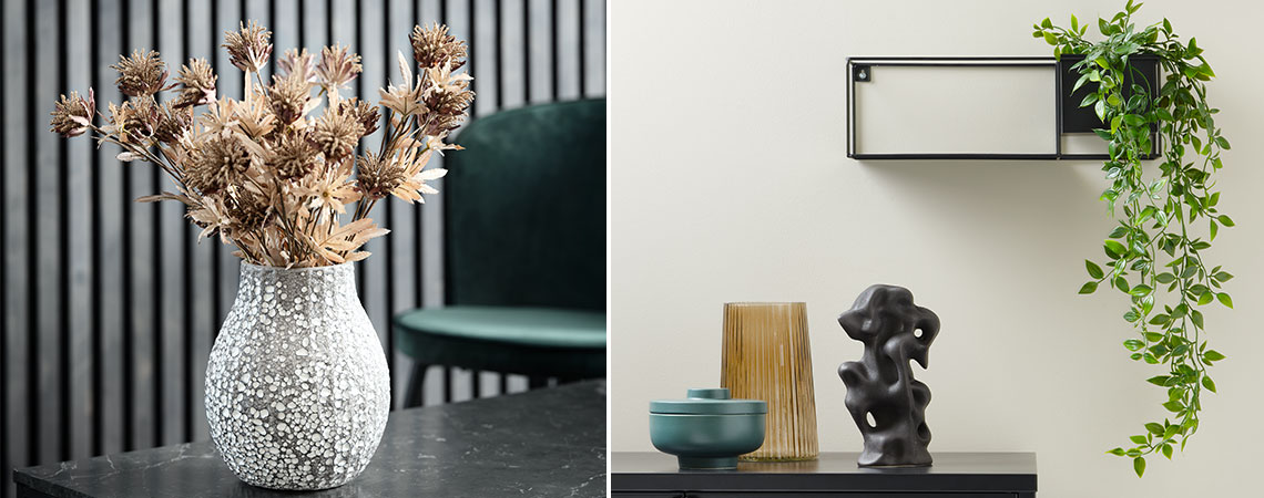 Faux flowers in vase next to artificial plant decoration on wall shelf 