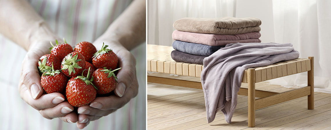 Create a summer feeling in your home with light colours Woman holding fresh strawberries in her hands and a daybed with a stack of throws in summer colours