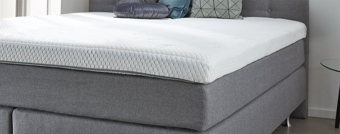 How much does a mattress topper cost? Bedroom with bed, mattress, mattress topper, and decorative cushions