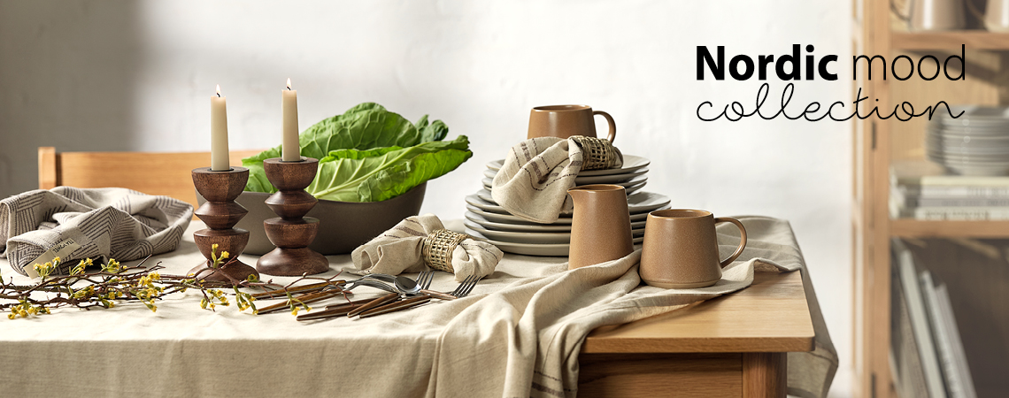The new Nordic Mood collection has tableware full of warmth and personality Tableware such as dinner plates, mug, milk jar, cutlery set, cloth napkins, and tablecloth on dining table