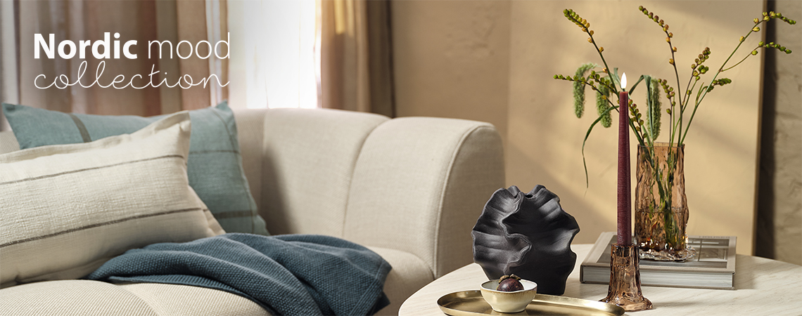 Living room with sofa and a coffee table with a glass vase and a candlestick 