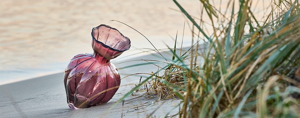 VILMER vase Decorative glass vase in aubergine-coloured glass on beach