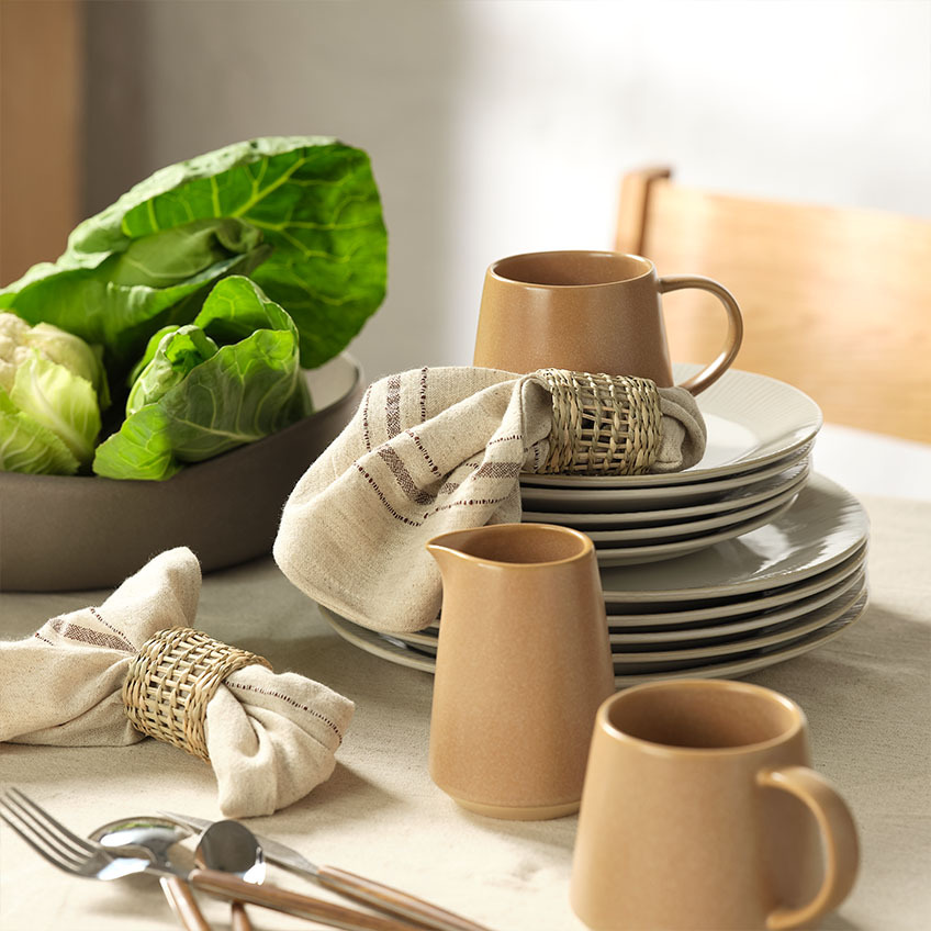 STEFFEN fluted plate in two sizes, OLLE mug and milk jug, and VEGARD bowl Tableware: White dinner plates and white dessert plates, mug, milk jug, cloth napkins with napkin rings, and salad bowl on dining table
