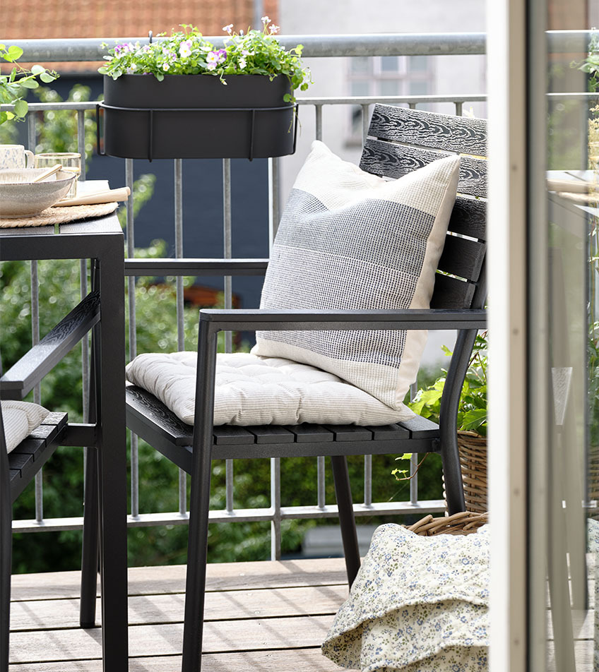 PADHOLM garden chair Black stacking garden chair with cushions on balcony