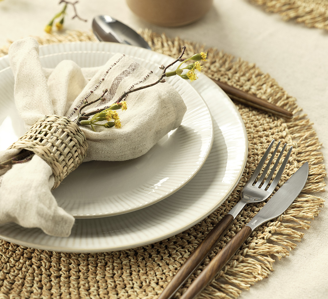 LIND placemat, STEFFEN plates and KASTANIE cloth napkins Place setting with a round place mat, plates, napkin and cutlery