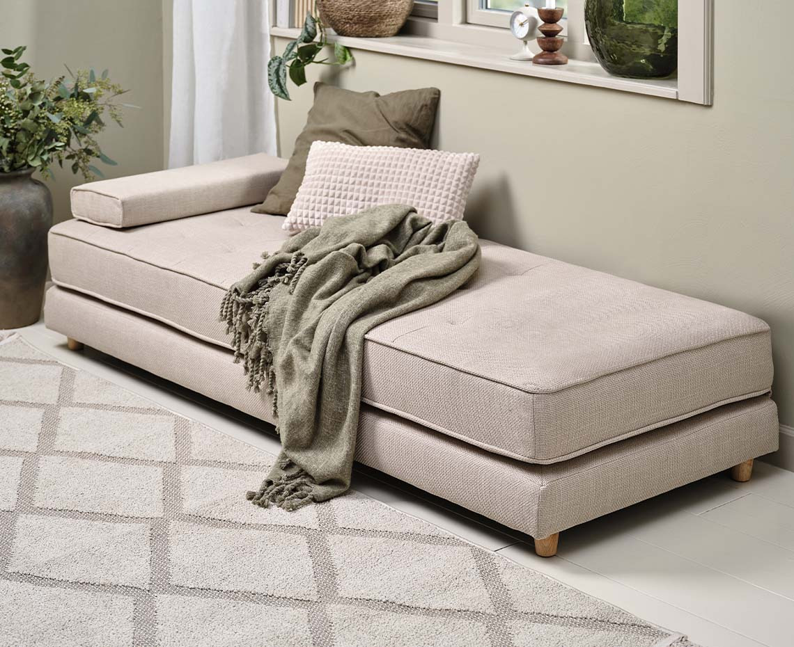 VARMARK daybed Beige daybed in living room with cushions and throw