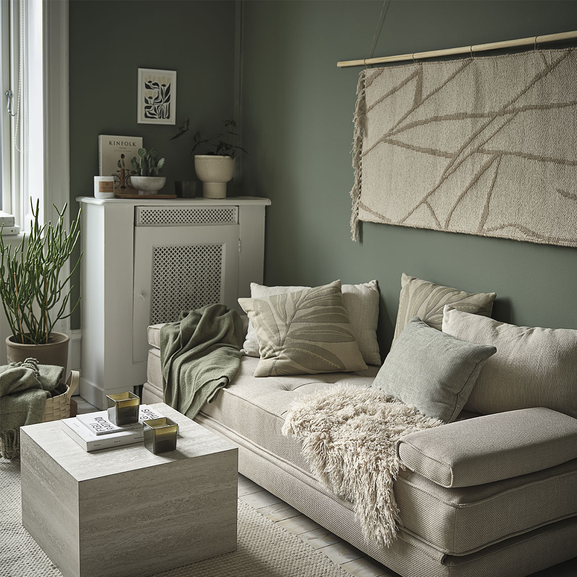 PLATAN rug, KORSKNAP lambskin, and VARMARK daybed Living room with rugs, throws, and cushions in beige and green tones