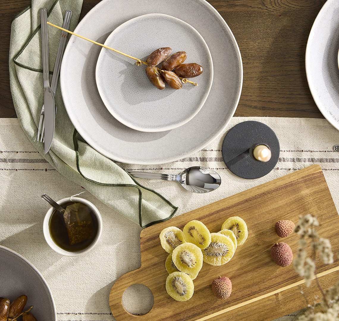 Dinner table with tableware, cutlery and cutting board