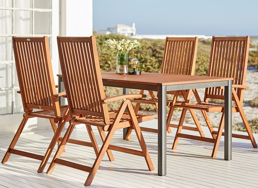 YTTRUP garden table and KAMSTRUP garden chairs Wooden garden furniture on a patio by the ocean