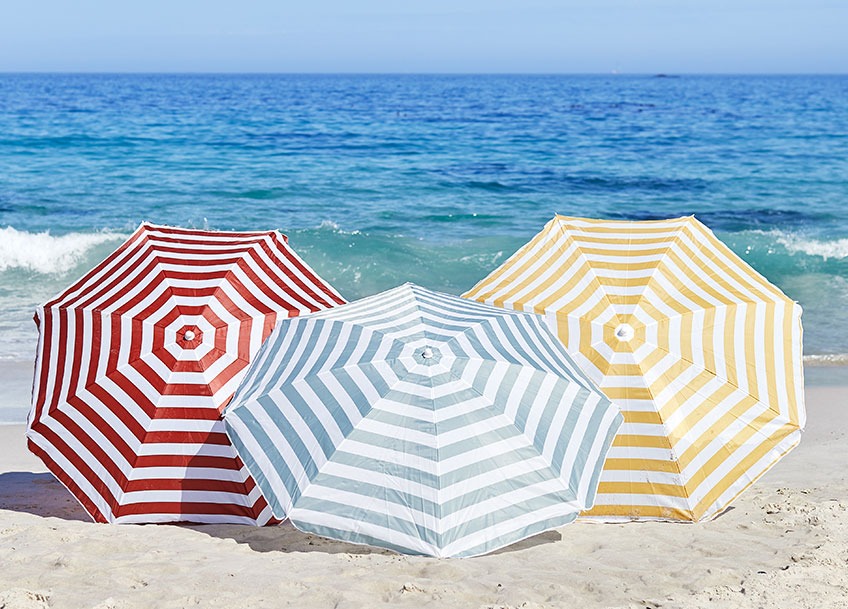 KATTEGAT parasols available in red, mint and yellow Three large parasols on a beach