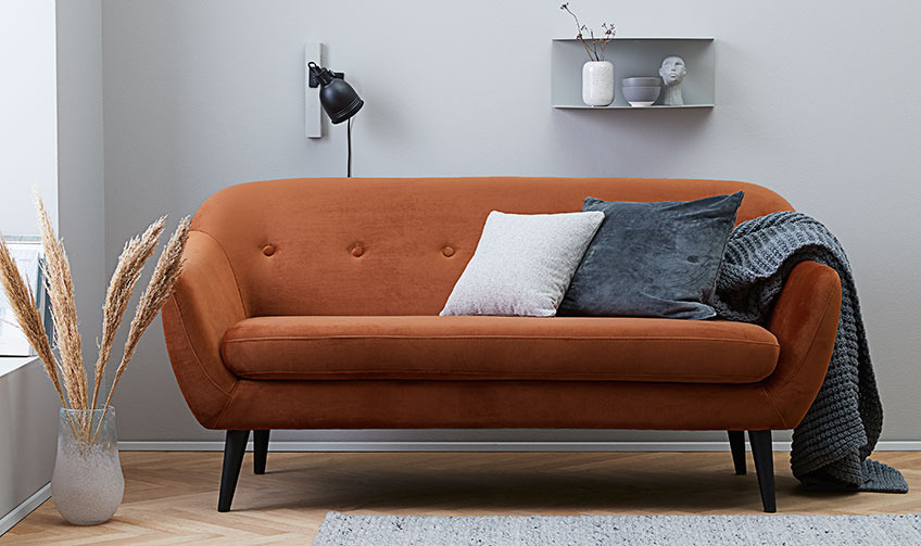 The EGEDAL sofa in orange velvet Living room with an orange sofa filled with cushions and a throw