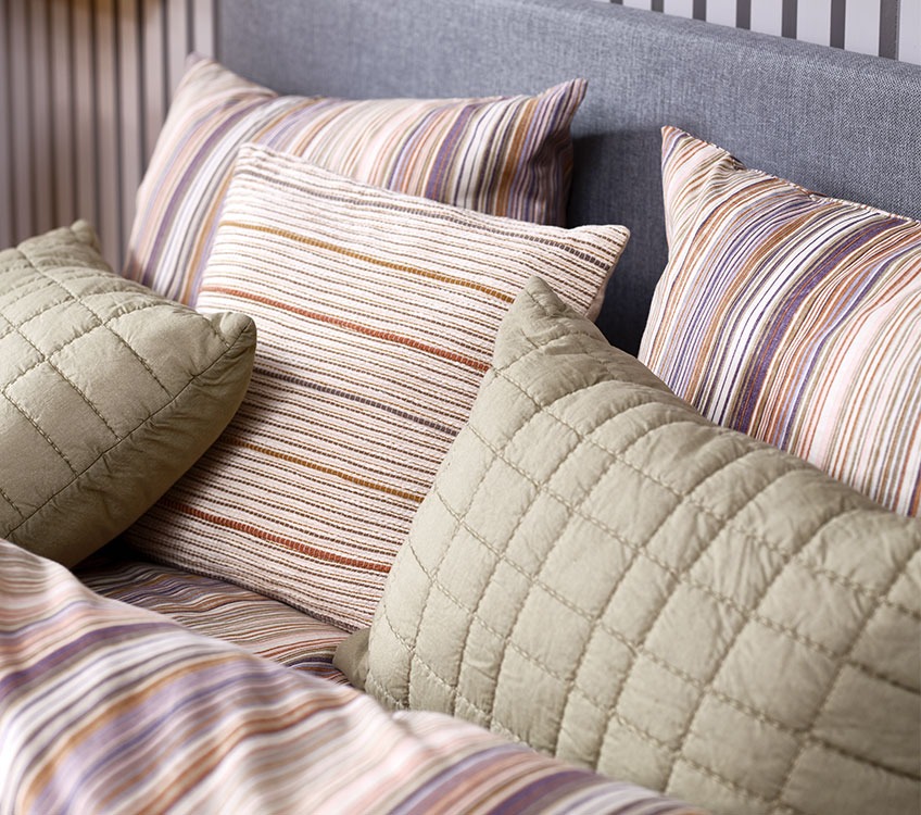 Green VALMUE cushions, MARSFIOL striped cushions and ABBIE bed linen Striped bedlinen with striped decorative cushions and green pillows