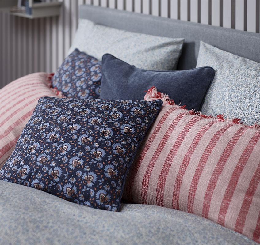 DAGFIOL, KROKUS and HORNFIOL decorative cushions Bed with decorative cushions in red and blue nuances