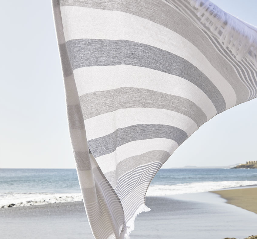 BACKA beach towel Striped towel blowing in the wind