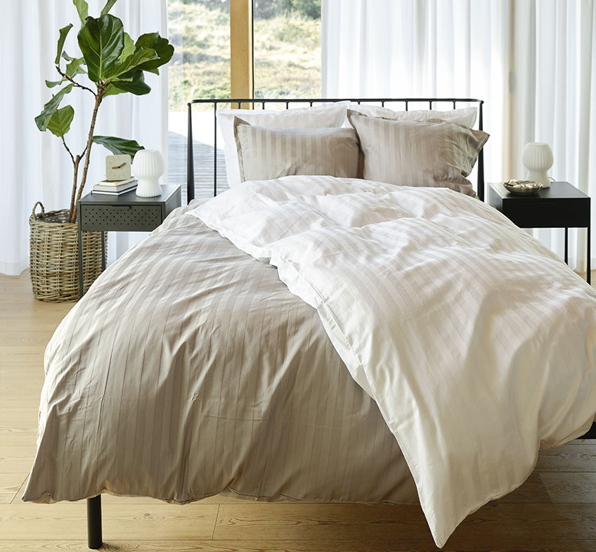 The stripes on NELL duvet cover set are woven into the fabric Bedroom with grey and white striped bedding on the bed and two bedside tables