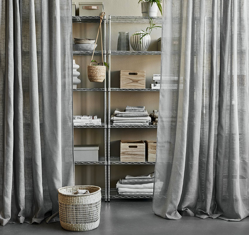 AGA linen-look curtains in grey Shelving unit in metal with grey sheer curtains in front